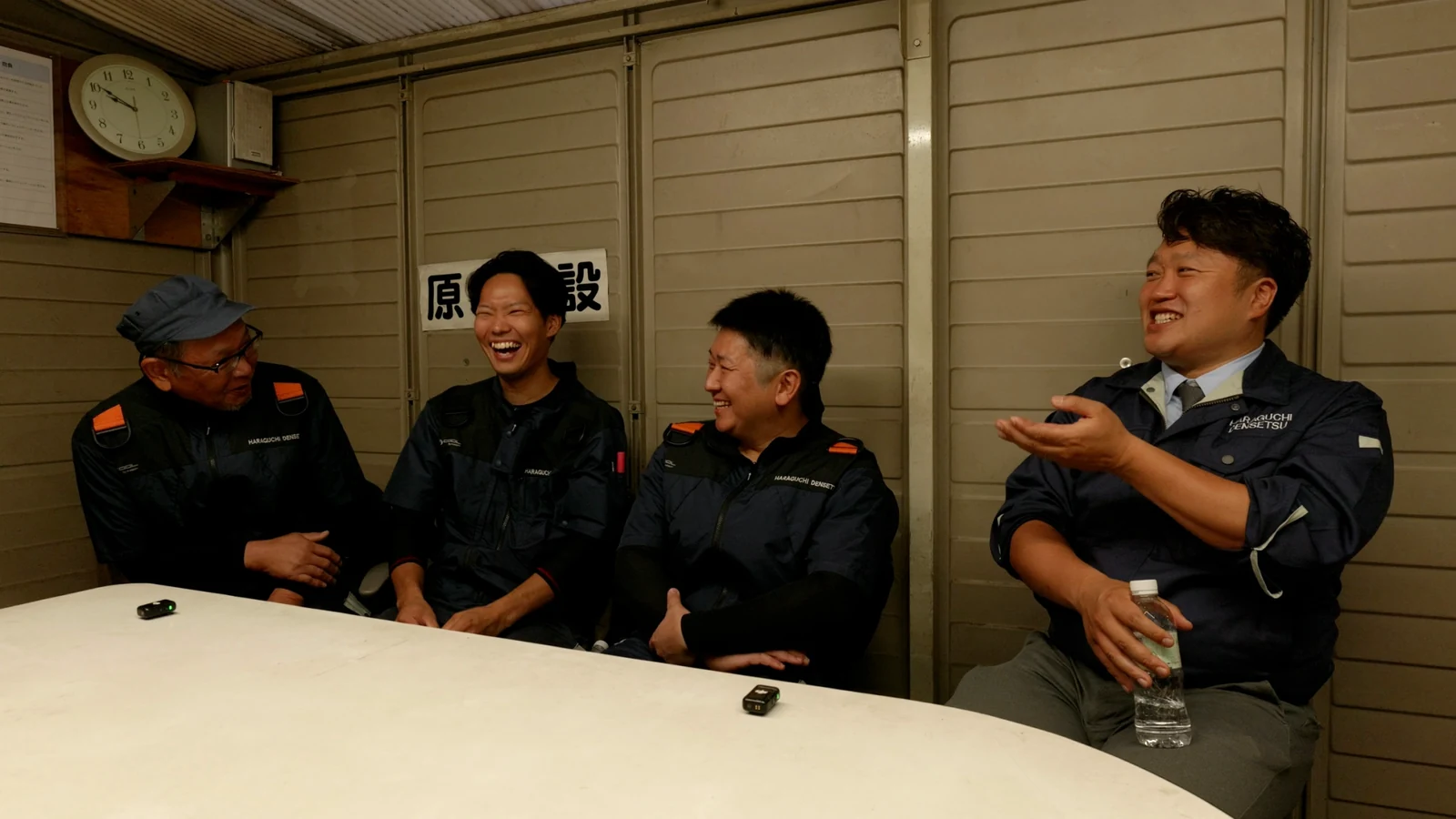 笑顔で会話する原口電設の社員たち